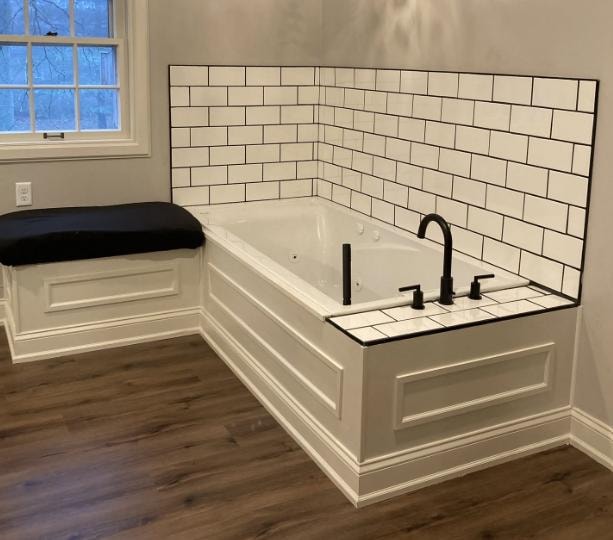 Bathroom remodel with subway tile surround, built-in tub, and black fixtures