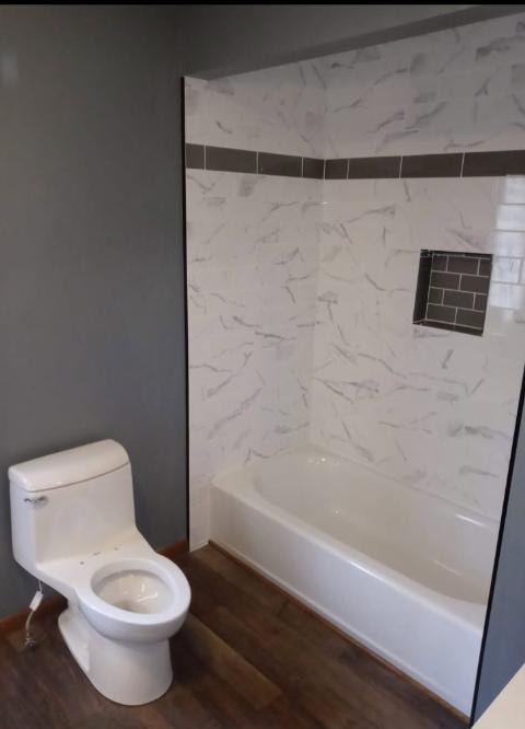 Bathroom renovation with marble-look tile surround and soaking tub