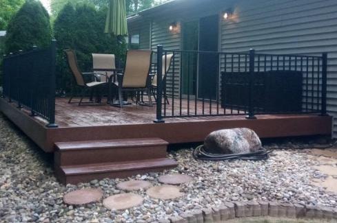 Composite deck build with black metal railing and step access