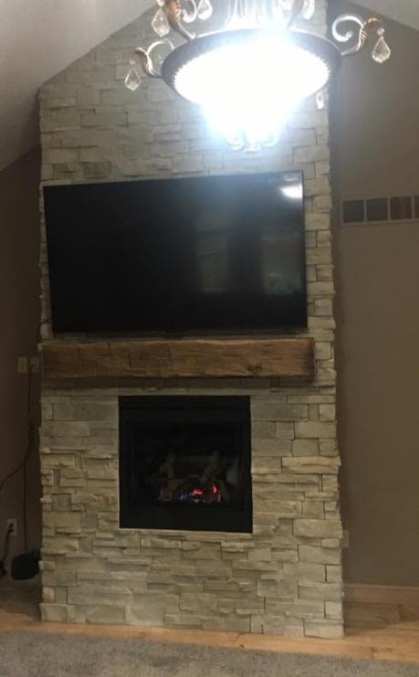 Full stacked stone fireplace with wood beam mantel