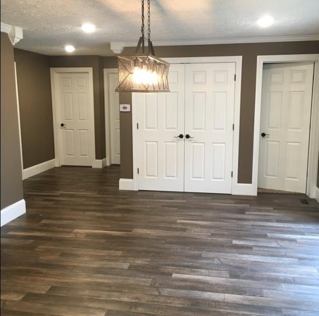 Interior remodel with dark hardwood flooring, white doors, crown molding, and pendant lighting