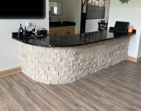 Custom curved stone bar with black granite countertop